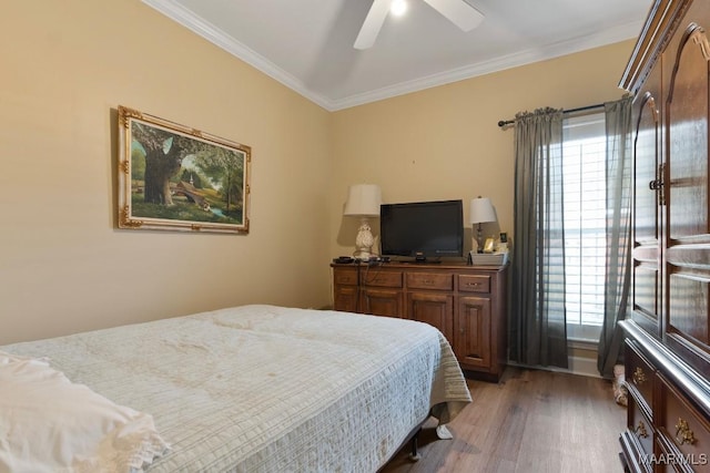 bedroom featuring multiple windows, dark hardwood / wood-style flooring, ornamental molding, and ceiling fan