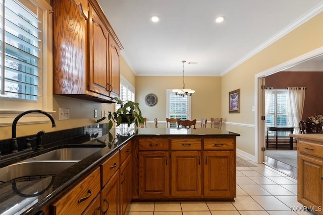 kitchen with light tile patterned floors, crown molding, sink, and kitchen peninsula