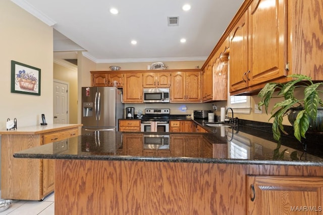 kitchen featuring sink, crown molding, appliances with stainless steel finishes, light tile patterned flooring, and kitchen peninsula