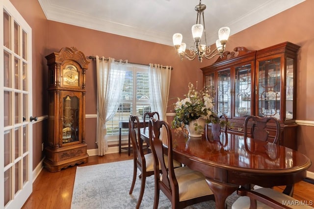 dining room featuring ornamental molding, a chandelier, and light hardwood / wood-style flooring