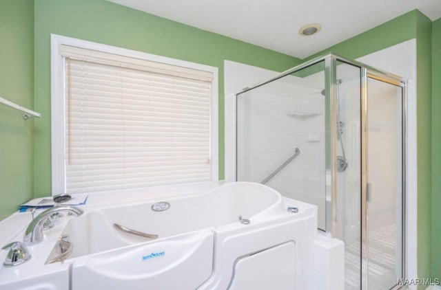 bathroom featuring independent shower and bath