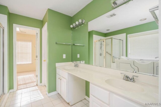 bathroom with tile patterned flooring, vanity, and walk in shower