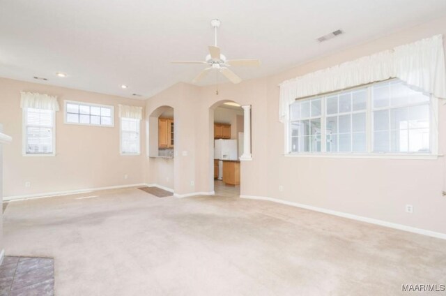 unfurnished living room with light colored carpet and ceiling fan