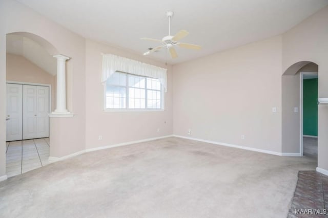 unfurnished room with ceiling fan, light colored carpet, and ornate columns