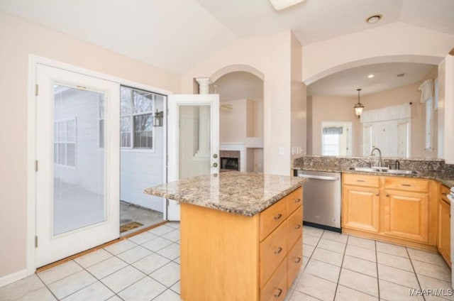 kitchen featuring sink, vaulted ceiling, dishwasher, a kitchen island, and light stone countertops