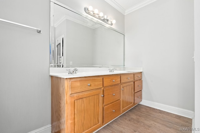 bathroom featuring wood-type flooring, ornamental molding, and vanity