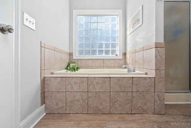 bathroom featuring plus walk in shower and hardwood / wood-style floors