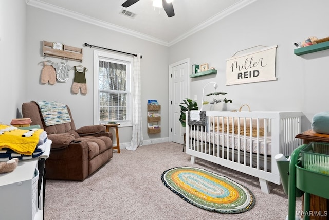 carpeted bedroom featuring ceiling fan, ornamental molding, and a crib