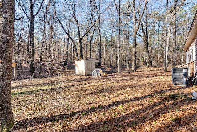 view of yard featuring central AC unit and a shed