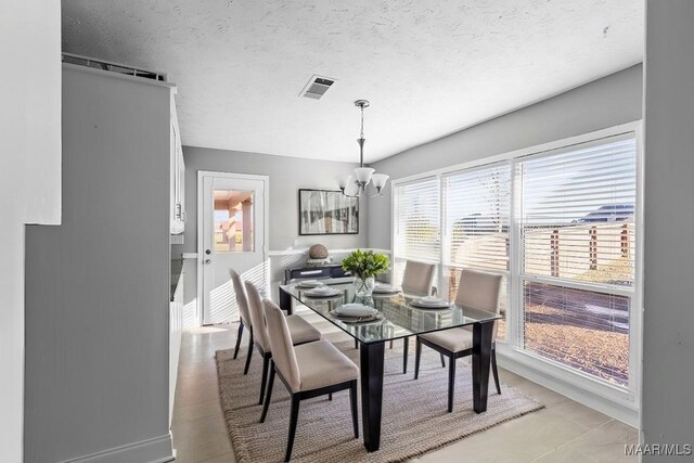 dining space with a notable chandelier and a textured ceiling