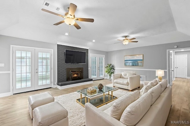 living room with ceiling fan, light wood-type flooring, and french doors