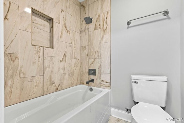 bathroom with toilet and tiled shower / bath