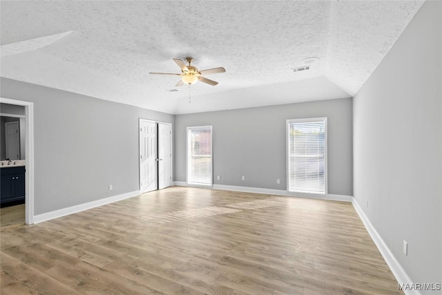 spare room featuring ceiling fan, light hardwood / wood-style flooring, and a textured ceiling