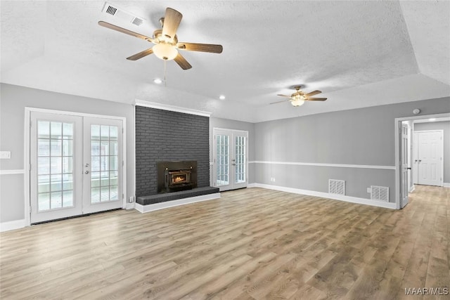 unfurnished living room featuring hardwood / wood-style flooring, french doors, and a textured ceiling