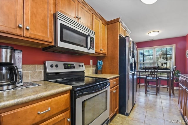 kitchen with light tile patterned floors and stainless steel appliances