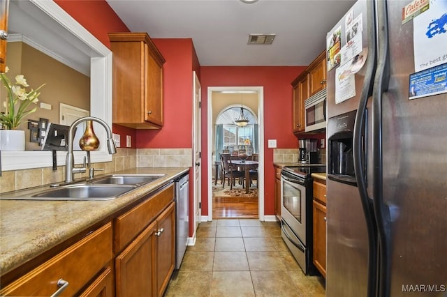 kitchen featuring ornamental molding, appliances with stainless steel finishes, sink, and light tile patterned floors