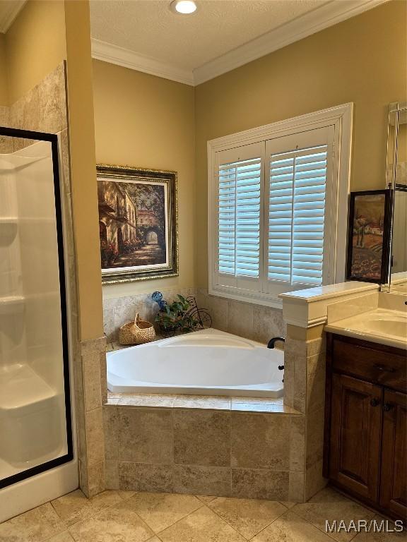 bathroom with vanity, tile patterned flooring, crown molding, and plus walk in shower