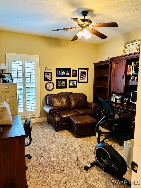 office space featuring a textured ceiling, carpet floors, and ceiling fan