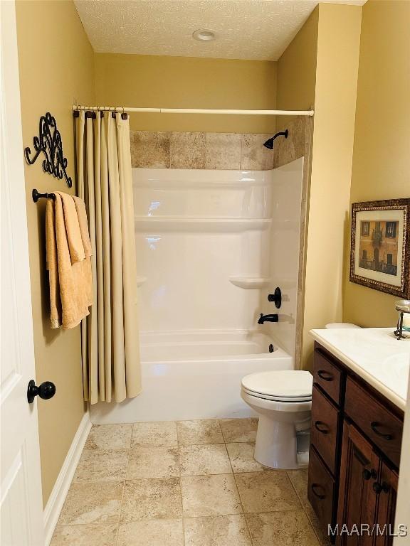 full bathroom featuring vanity, shower / bath combo, toilet, and a textured ceiling