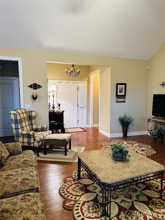 living room with hardwood / wood-style flooring and a notable chandelier