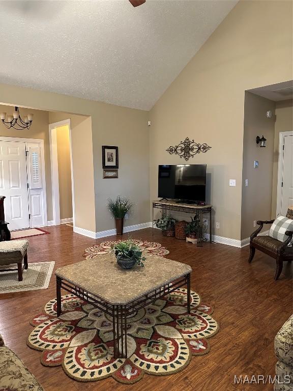 living room featuring ceiling fan with notable chandelier, high vaulted ceiling, and dark hardwood / wood-style floors