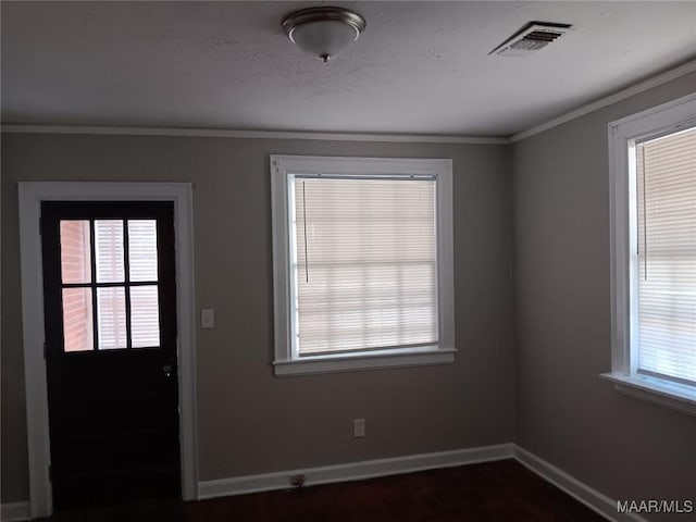 foyer with crown molding and a wealth of natural light