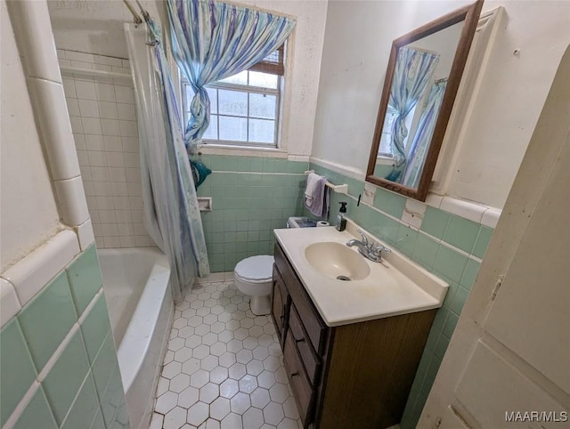 full bathroom with tile walls, vanity, toilet, and shower / bathtub combination with curtain