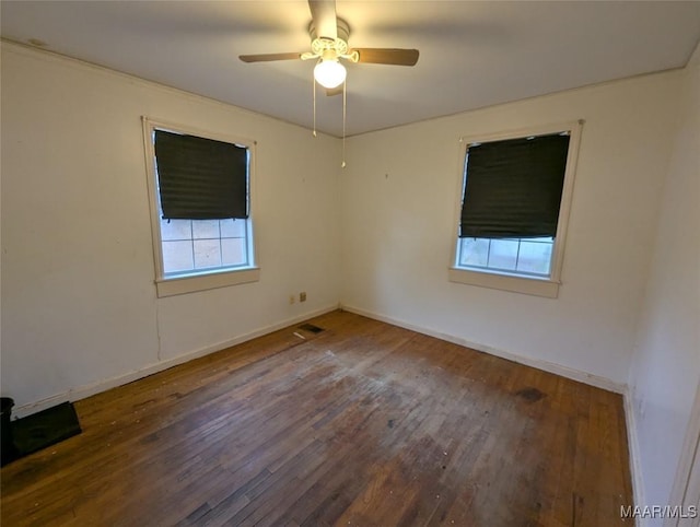 empty room featuring dark wood-type flooring and ceiling fan