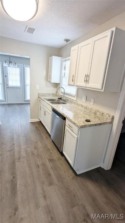 kitchen with white cabinetry, sink, stainless steel dishwasher, and a textured ceiling