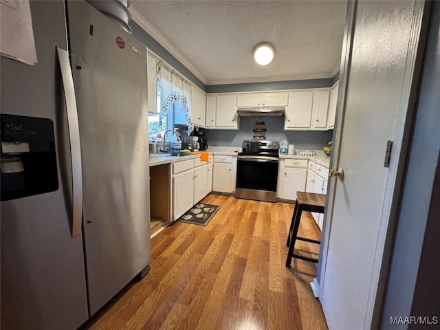 kitchen with sink, light hardwood / wood-style flooring, stainless steel appliances, a textured ceiling, and white cabinets