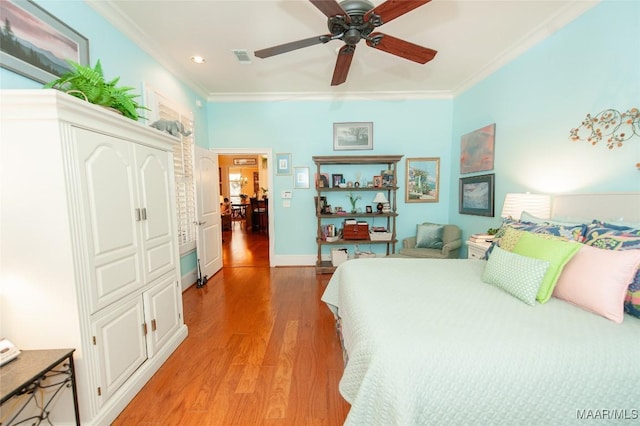 bedroom featuring ceiling fan, ornamental molding, hardwood / wood-style floors, and a closet