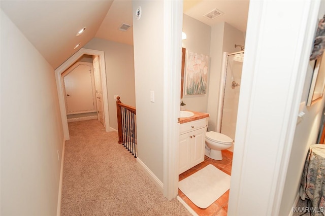 bathroom featuring lofted ceiling, vanity, toilet, and walk in shower