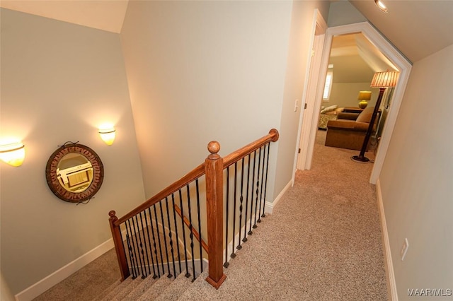 hallway with lofted ceiling and light carpet