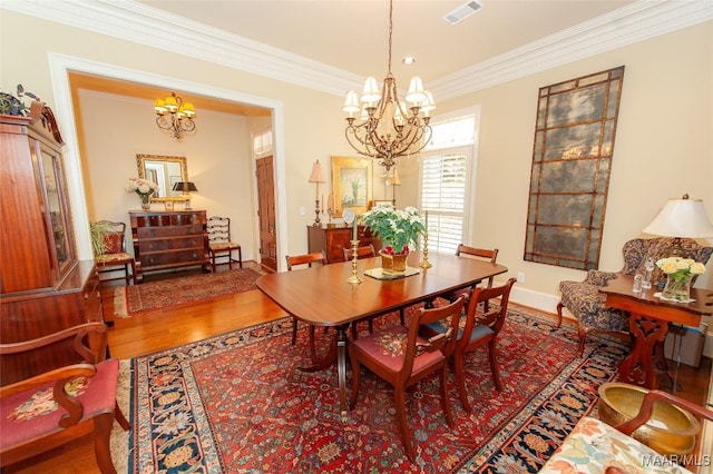 dining area featuring hardwood / wood-style flooring, crown molding, and a notable chandelier