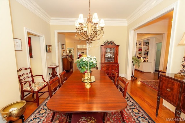 dining space featuring crown molding, an inviting chandelier, and hardwood / wood-style floors