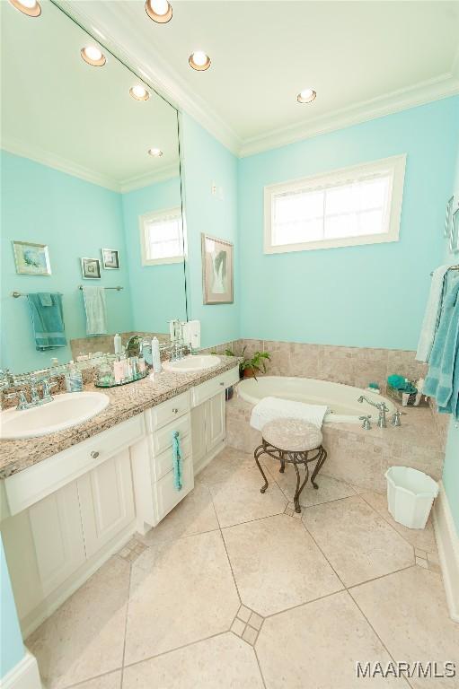 bathroom featuring vanity, crown molding, tile patterned floors, and a tub