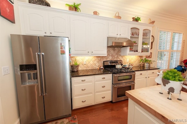 kitchen featuring dark hardwood / wood-style floors, white cabinets, backsplash, ornamental molding, and stainless steel appliances