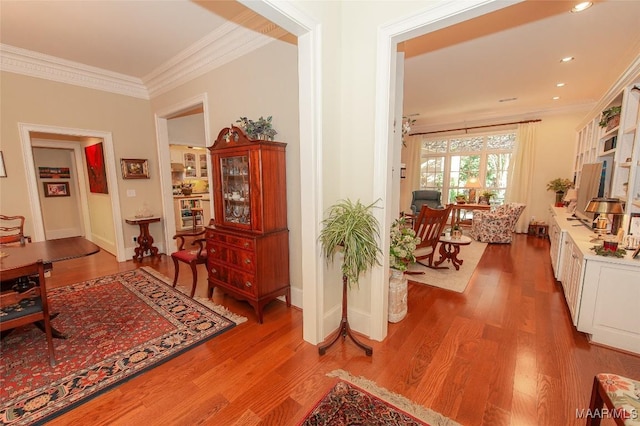 corridor featuring ornamental molding and wood-type flooring