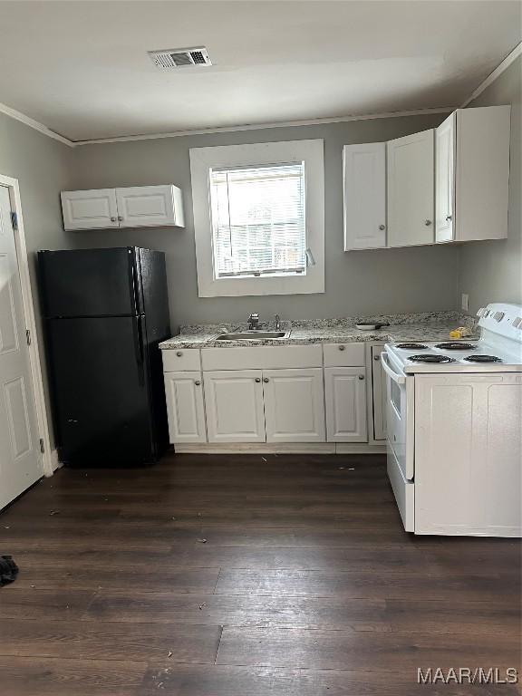 kitchen featuring black refrigerator, sink, white electric stove, and white cabinets