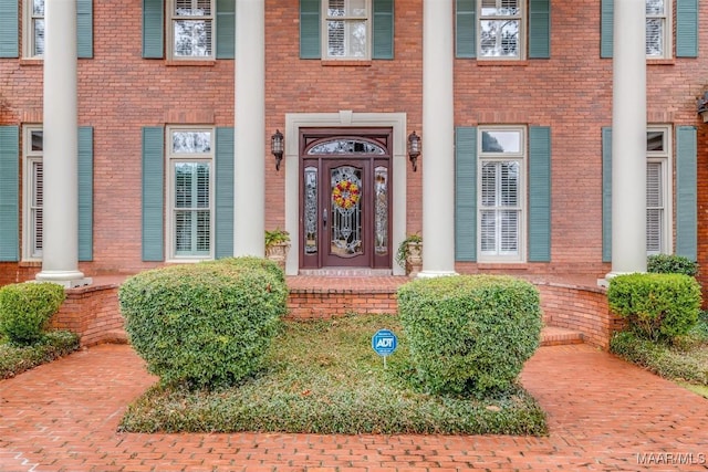 entrance to property featuring brick siding