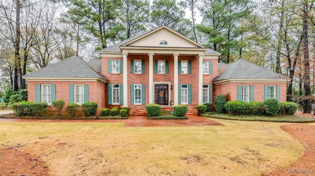 greek revival house with brick siding and a front lawn