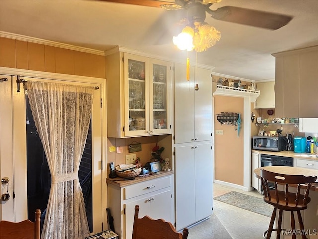 kitchen with crown molding, dishwashing machine, and white cabinets