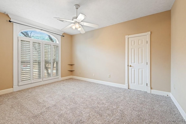 carpeted spare room featuring a ceiling fan, a textured ceiling, and baseboards