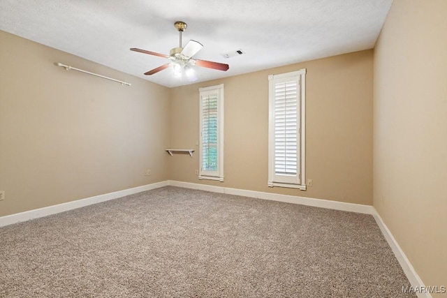 spare room featuring a ceiling fan, carpet flooring, visible vents, and baseboards