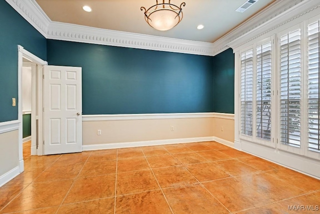 empty room with light tile patterned floors, baseboards, visible vents, and crown molding