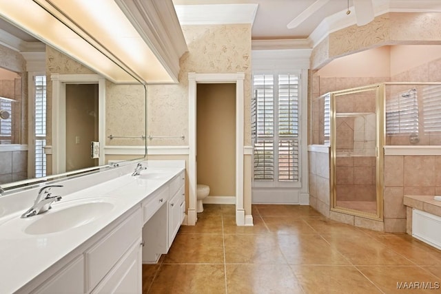 full bathroom with toilet, a sink, ornamental molding, a shower stall, and double vanity