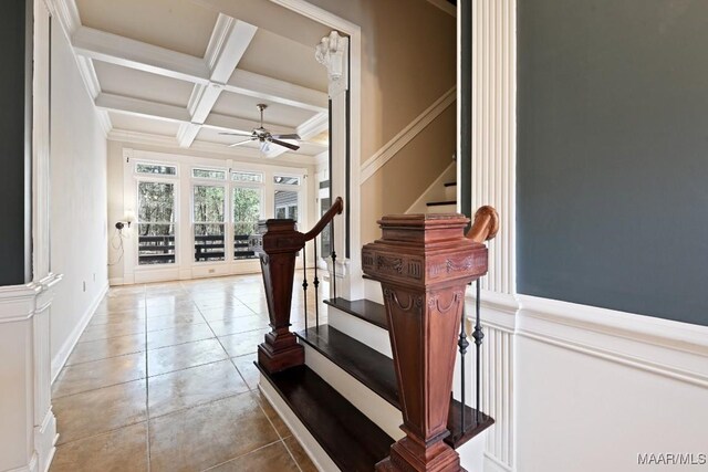 stairway featuring beam ceiling, ornamental molding, ceiling fan, tile patterned flooring, and coffered ceiling