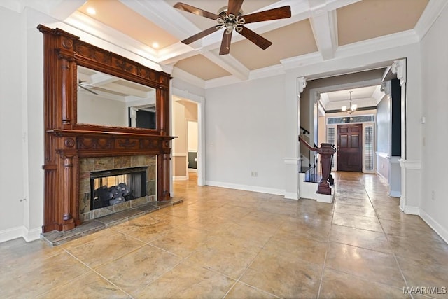 unfurnished living room with coffered ceiling, a tiled fireplace, crown molding, and ceiling fan with notable chandelier