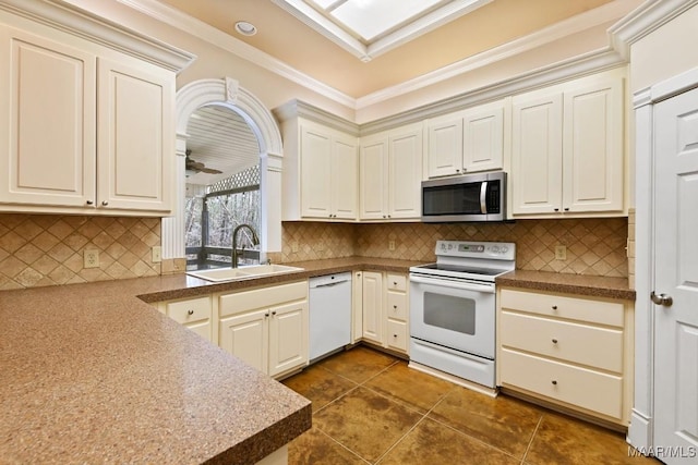 kitchen featuring ceiling fan, white appliances, a sink, ornamental molding, and decorative backsplash