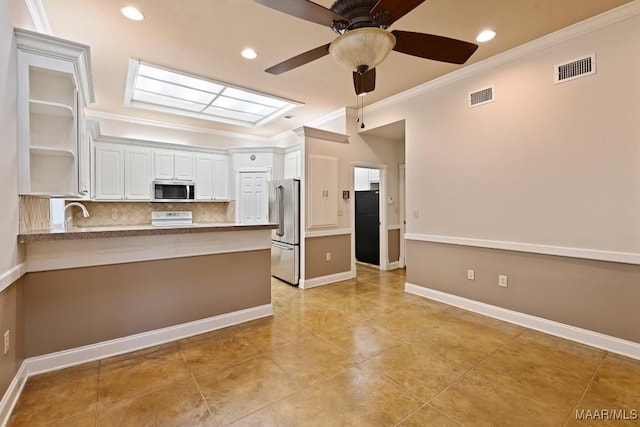 kitchen featuring stainless steel appliances, backsplash, visible vents, a ceiling fan, and a peninsula
